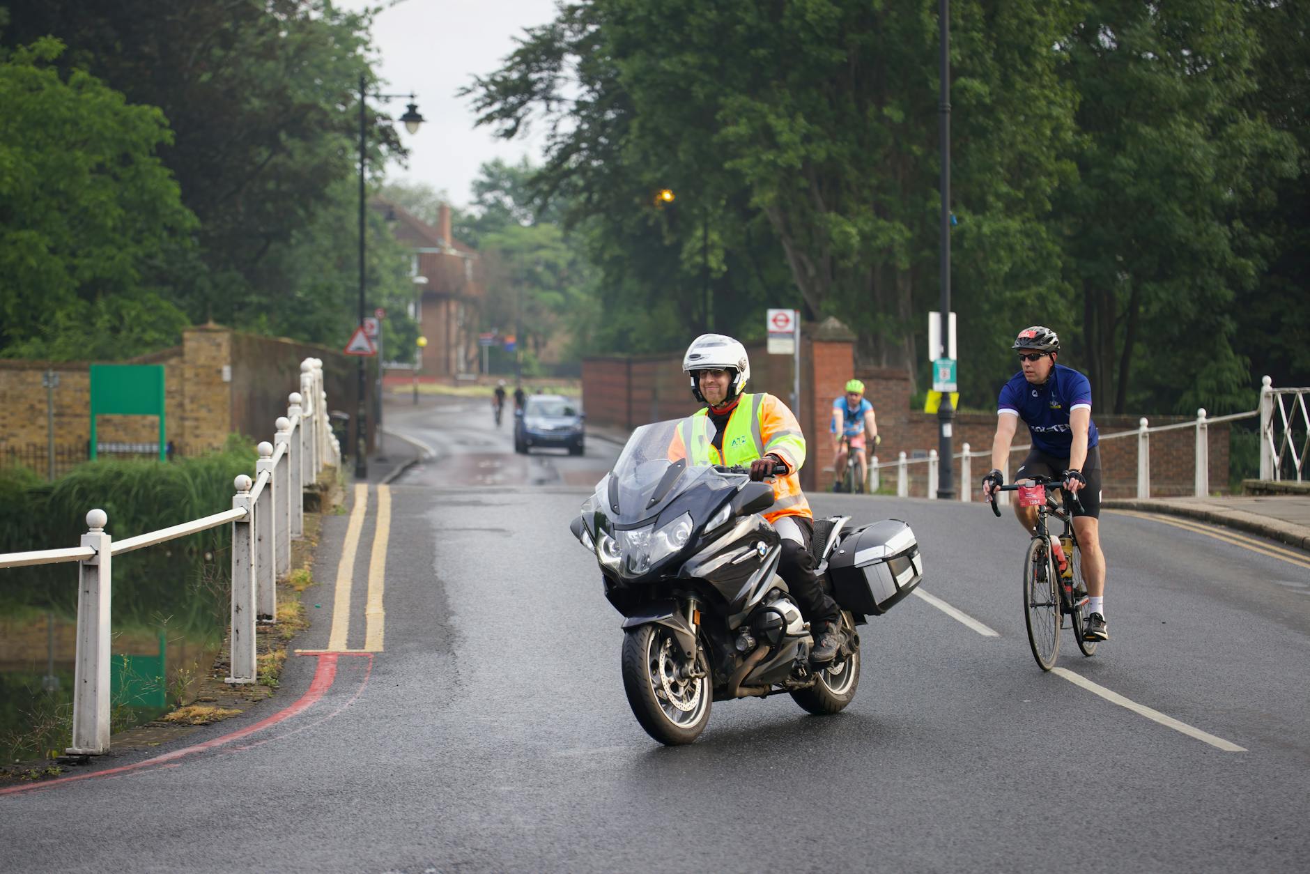 Kolarz i motocyklista podczas charytatywnego wydarzenia na malowniczej trasie