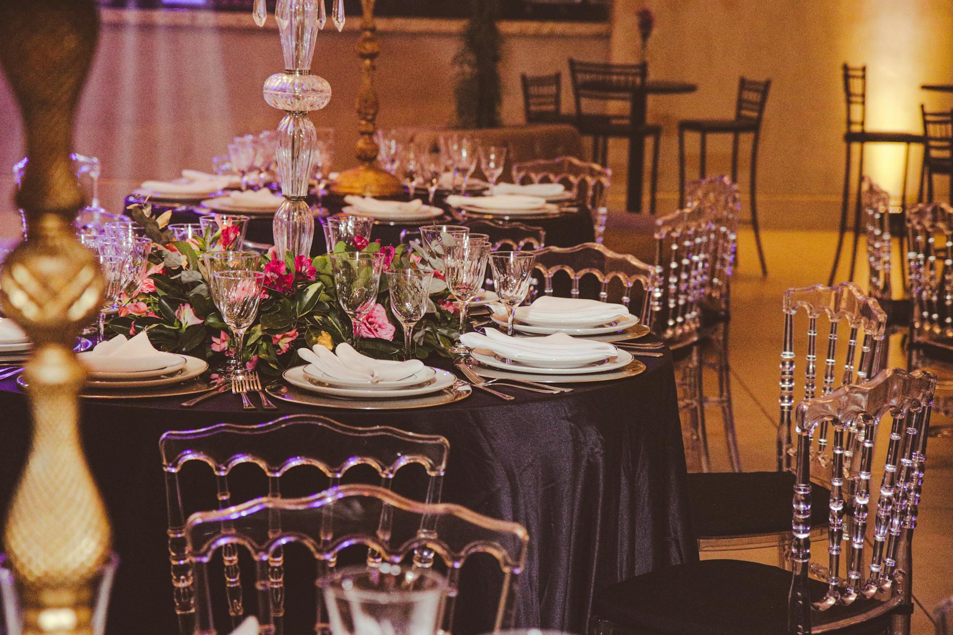 Elegancko nakryty stół z kwiatami i kryształem w sali balowej