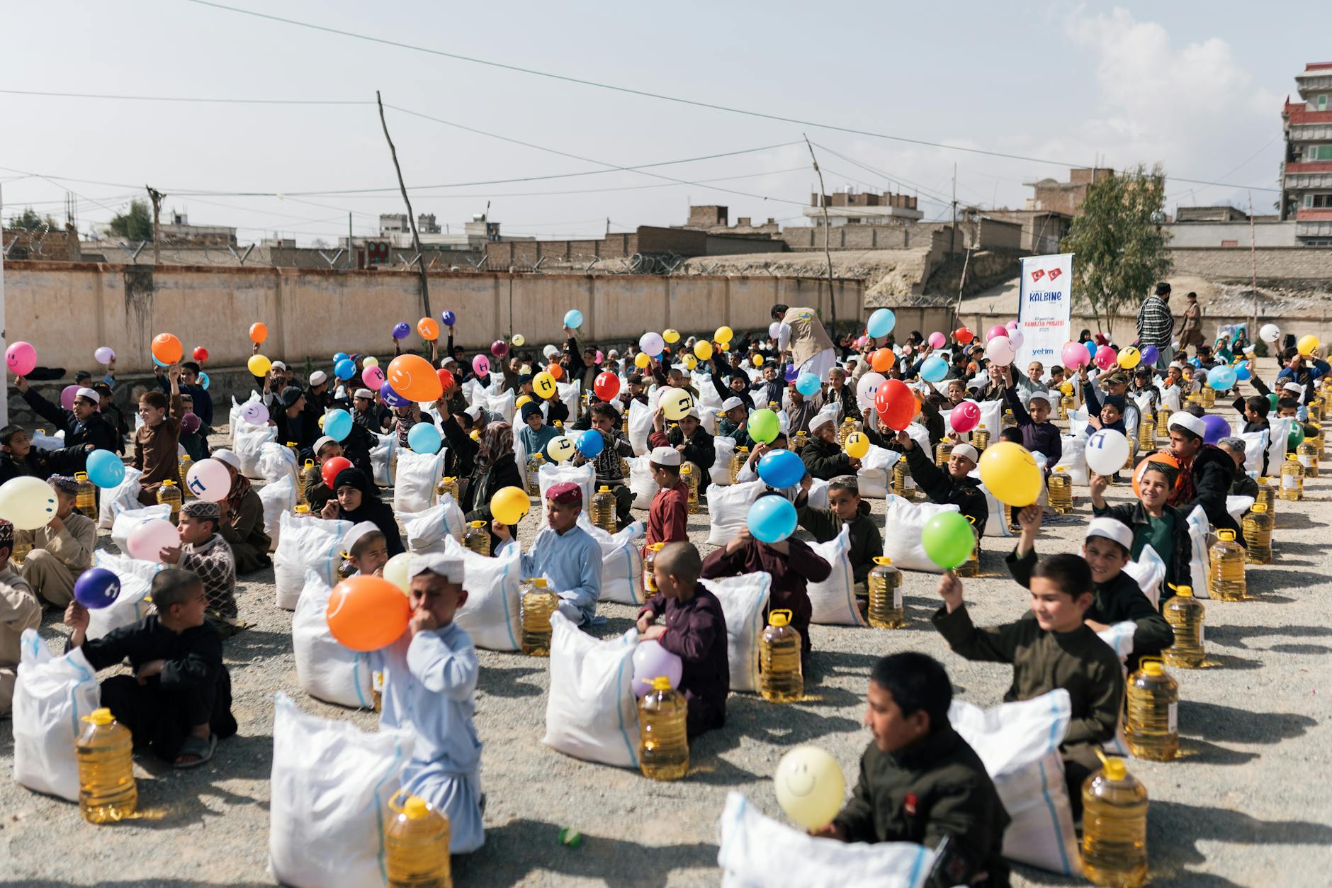 Dzieci z balonami i przyborami szkolnymi na dziennym evencie w Afganistanie