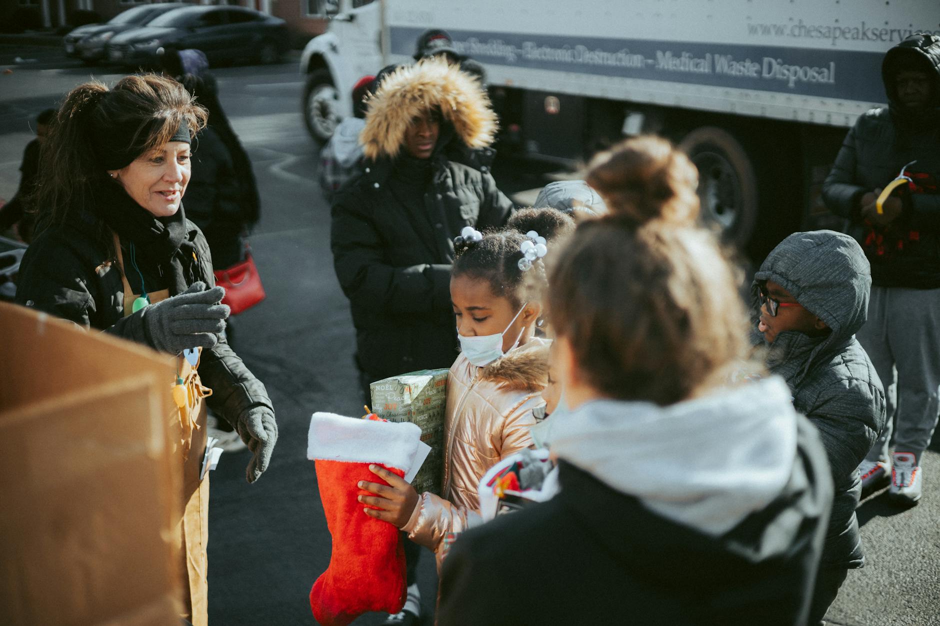 Mieszkańcy rozdają świąteczne prezenty na zewnątrz podczas spotkania