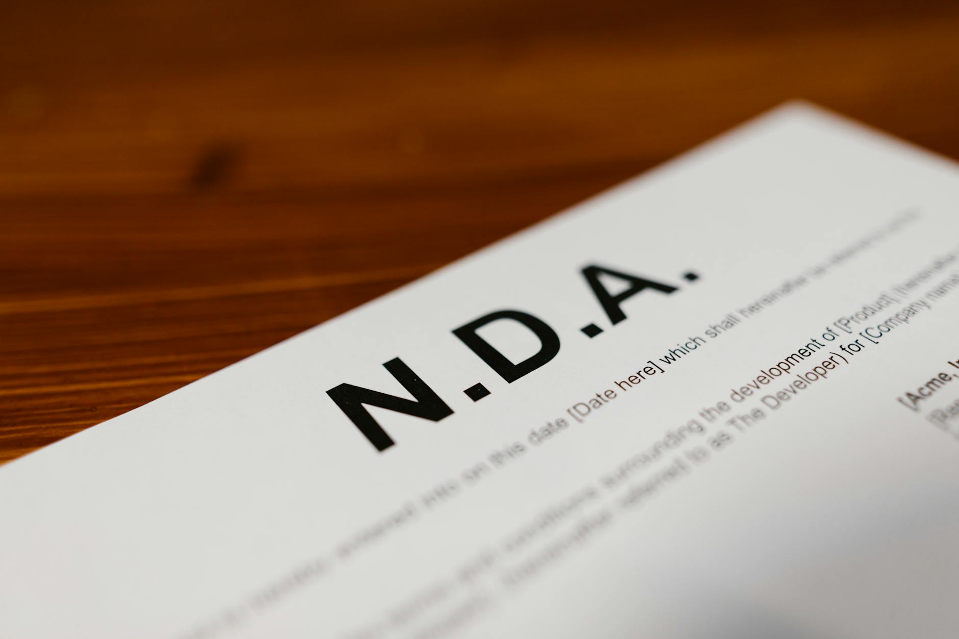 Zbliżenie na dokument NDA z danymi na drewnianym biurku
