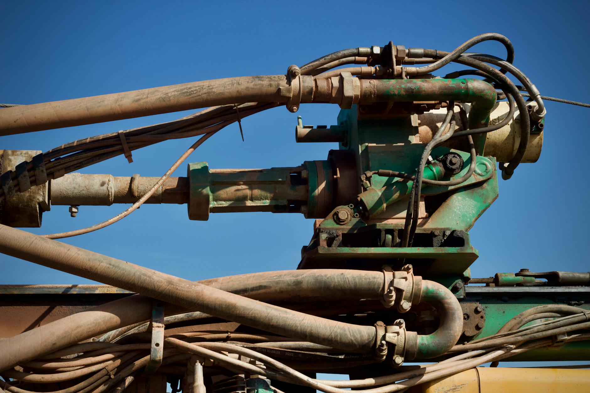 Zbliżenie na przemysłowe rury i koła zębate na tle nieba
