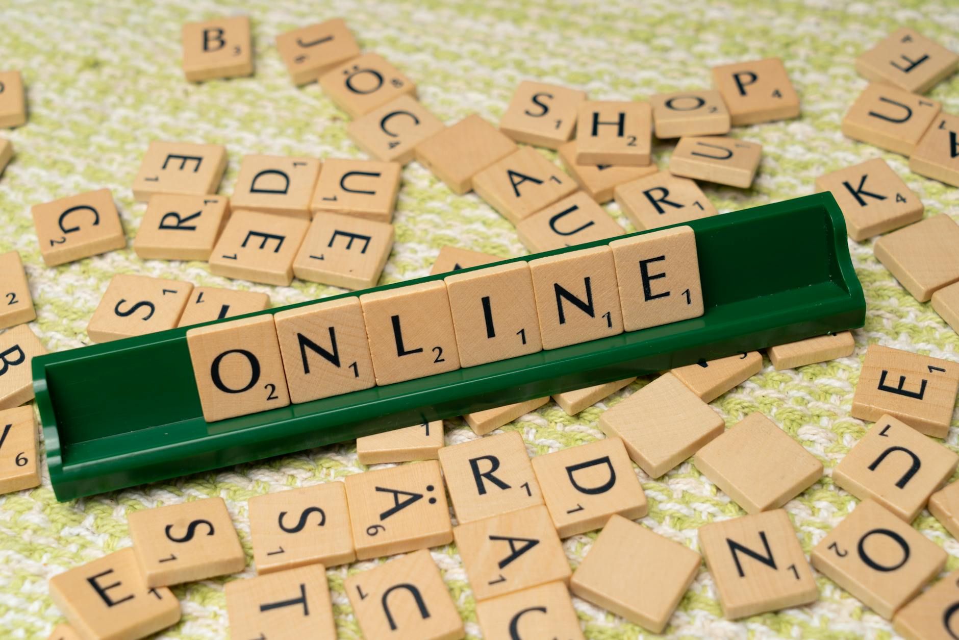 Kafelki scrabble układające się w słowo online na zielonej podstawce