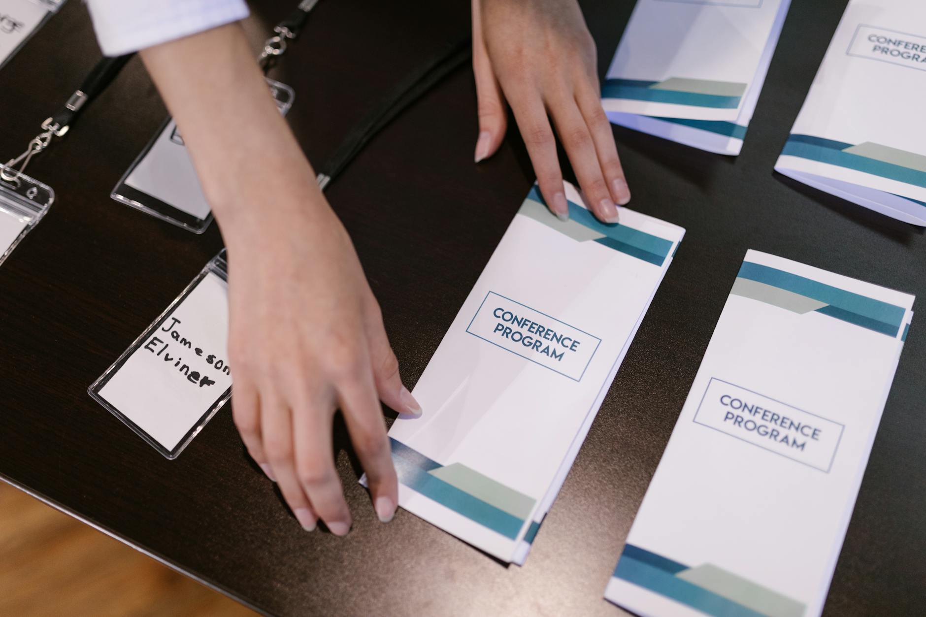 Recepcja wydarzenia z osobą układającą programy konferencji i identyfikatory
