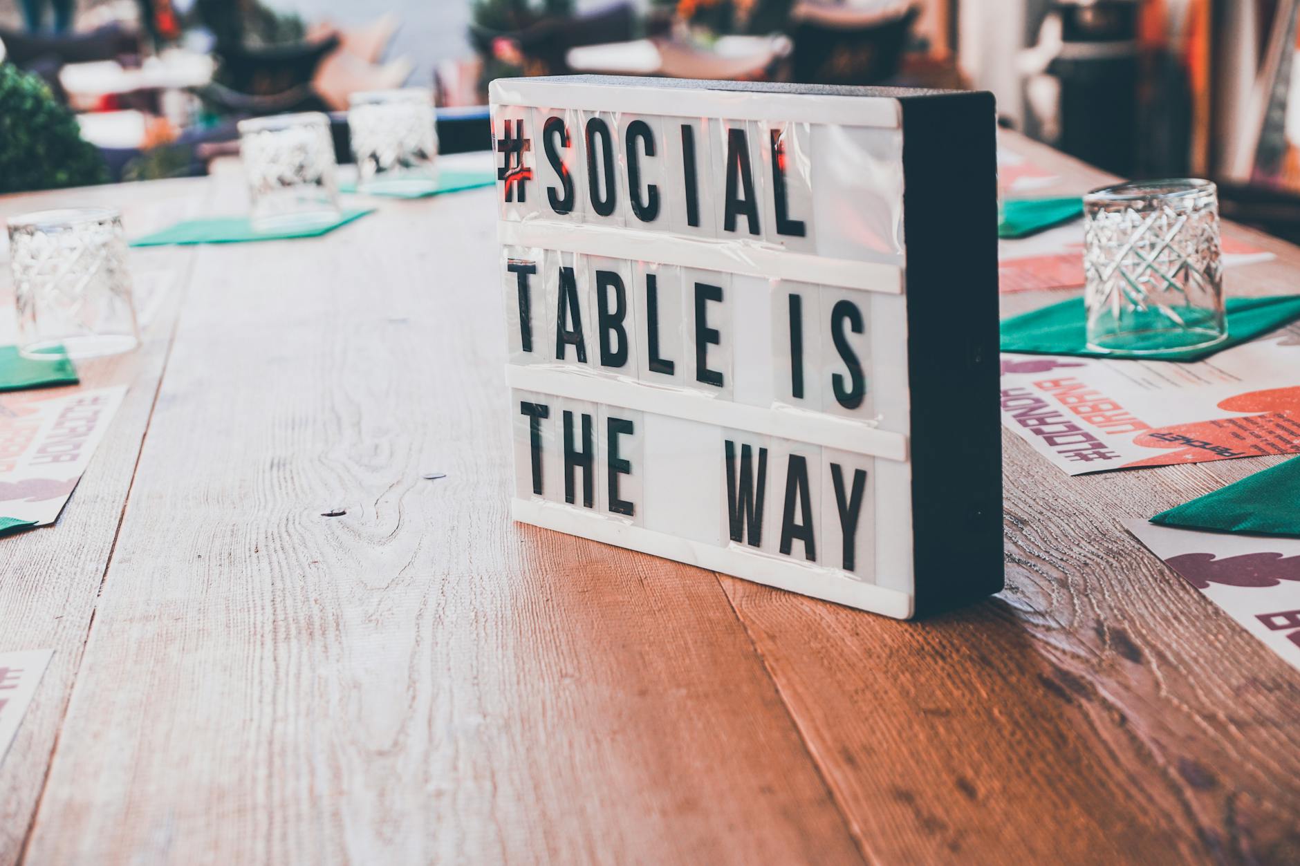 Tabliczka z napisem social message leży na drewnianym stole na zewnątrz