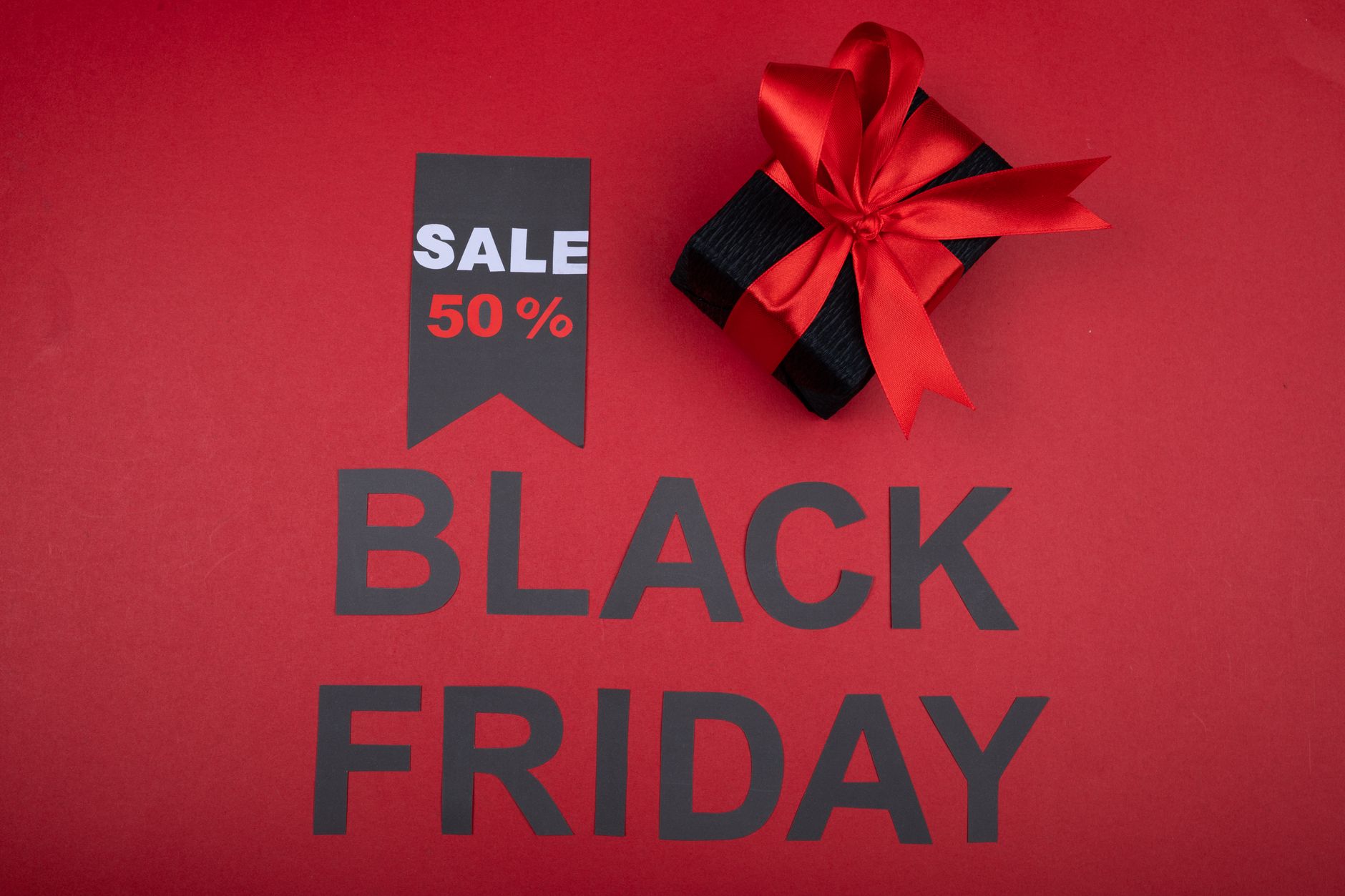 Czerwone pudełko prezentowe i baner promocji Black Friday minus 50%