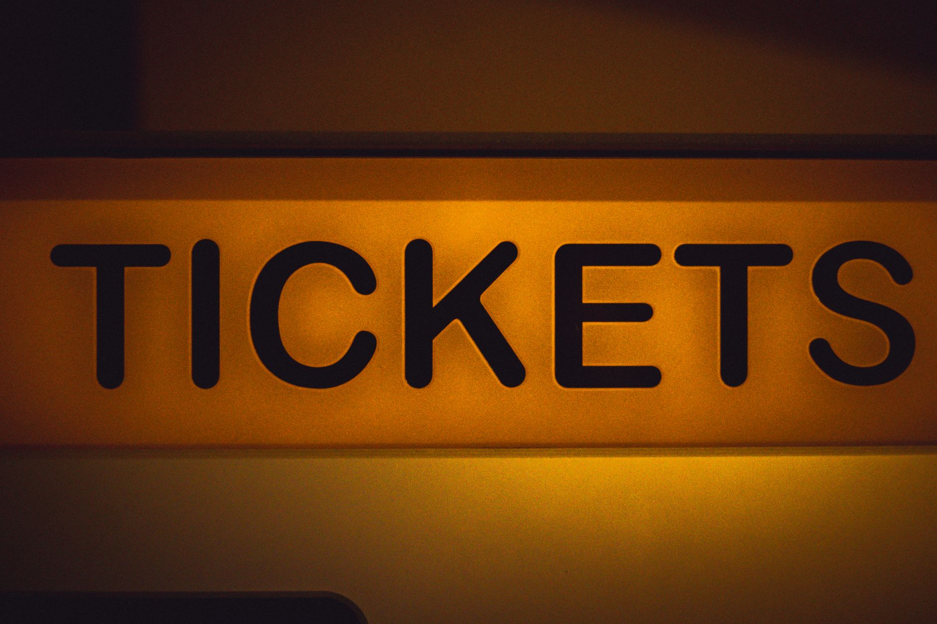Podświetlony żółty napis Tickets na ciemnym tle
